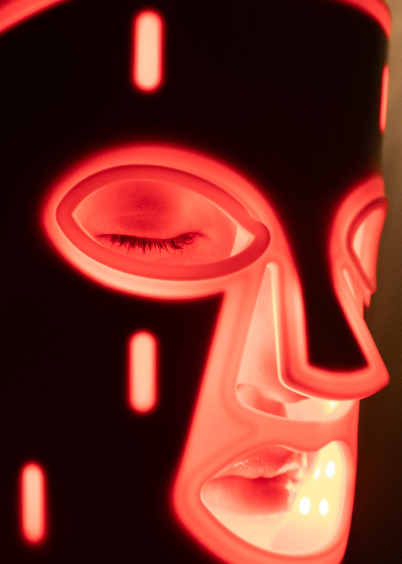 Close-up detail of PHOS Face Mask showing red LED light output and medical-grade silicone contour around eyes and nose